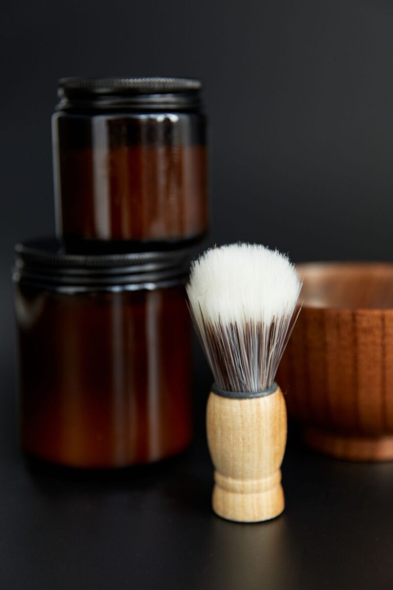 Blaireau et pots de soins sur fond sombre (photo d'illustration, Man's Beard Santalum)