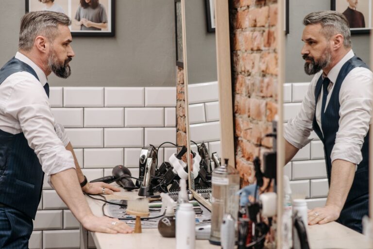 Homme barbu devant le miroir d’un barbershop (photo d'illustration, Plisson)