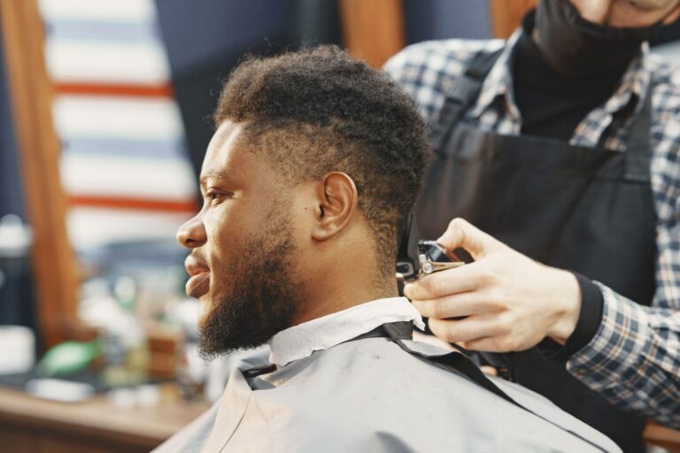 Homme barbu chez le barbier pendant une coupe (photo d'illustration, Philips Bodygroom 7000)