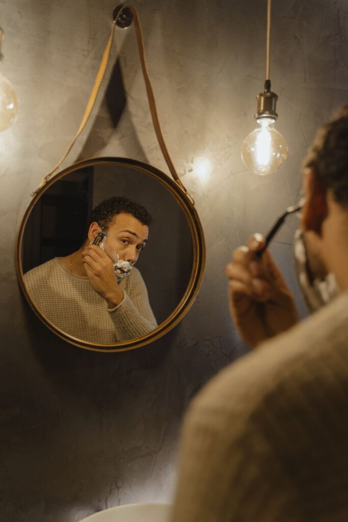 Homme entretenant sa barbe devant un miroir